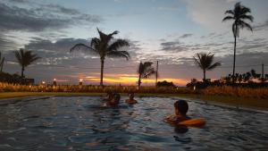 un grupo de personas en una piscina al atardecer en Calypso Sunset en Iranawila