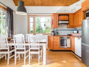 - une cuisine avec des placards en bois, une table et des chaises dans l'établissement Holiday Home Casa rocala by Interhome, à Tahkovuori