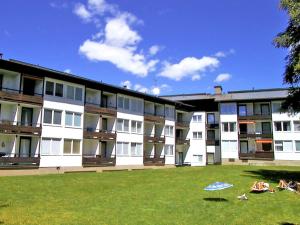 a group of people laying on the grass in front of a building at Apartment Alpenland-22 by Interhome in Seefeld in Tirol