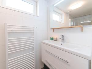a white bathroom with a sink and a mirror at Holiday Home Ruisweg 59 by Interhome in Wemeldinge