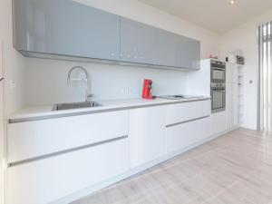 a kitchen with white cabinets and a sink at Holiday Home Ruisweg 59 by Interhome in Wemeldinge