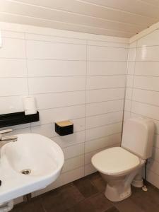 La salle de bains est pourvue de toilettes blanches et d'un lavabo. dans l'établissement Surnadal Camping Brekkøya, à Surnadal