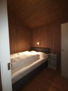 - une chambre avec un grand lit et un mur en bois dans l'établissement Surnadal Camping Brekkøya, à Surnadal