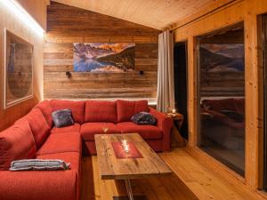 - un salon avec un canapé rouge et une table dans l'établissement Chalet Panoramo by Interhome, à Klippitztorl