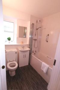 a bathroom with a toilet and a tub and a sink at Apartment Seaside Apartment by Interhome in Oban