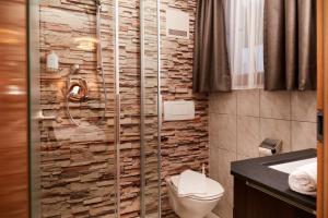a bathroom with a toilet and a stone wall at Dà Ingo - Apartments & More in Damuls +29 photos