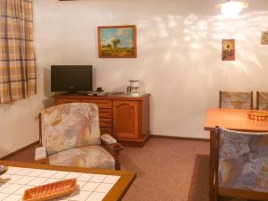 - un salon avec un bureau, une télévision et une chaise dans l'établissement Apartment Am Hohen Bogen-38 by Interhome, à Arrach
