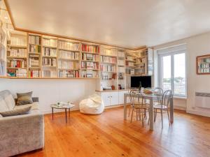 a living room with a table and chairs and bookshelves at Apartment Ker Louis 2 by Interhome in Dinard