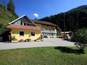żółty dom z samochodem zaparkowanym przed nim w obiekcie Apartment Schwarzwald 6 OG by Interhome w mieście Radenthein