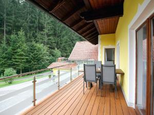 a deck with two chairs and a table on it at Apartment Schwarzwald by Interhome in Radenthein