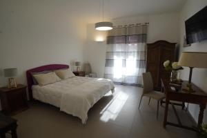 sypialnia z białym łóżkiem, biurkiem i krzesłem w obiekcie B&B Bivona w mieście Mazara del Vallo