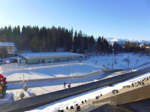 a snow covered ski slope in front of a building at Apartment les Vignettes by Interhome in Crans-Montana