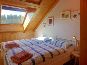 a bedroom with a large bed with a window at Apartment les Vignettes by Interhome in Crans-Montana