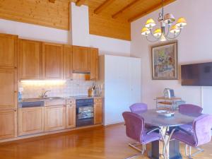 a kitchen with a table and purple chairs in it at Apartment les Vignettes by Interhome in Crans-Montana