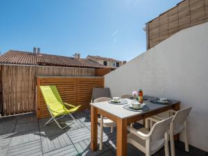 een patio met een tafel en stoelen op een balkon bij Holiday Home Les Maisons de la Plage-12 by Interhome in Le Grau-du-Roi