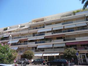 un immeuble d'appartements avec des voitures garées devant lui dans l'établissement Apartment Presqu'Ile by Interhome, à Cannes