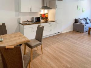 a kitchen and living room with a table and a couch at Apartment Spiekeroog by Interhome in Westerholt