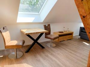 a table and two chairs in a room with a skylight at Apartment Baltrum by Interhome in Westerholt