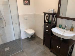 a bathroom with a toilet and a sink and a shower at Apartment Borkum by Interhome in Westerholt