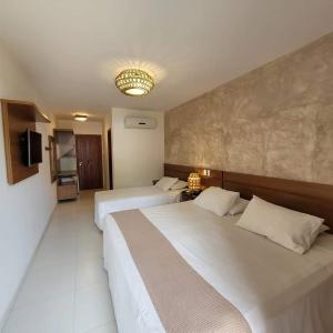 pokój hotelowy z 2 łóżkami i telewizorem w obiekcie Aquarela Praia Hotel w mieście Arraial d'Ajuda