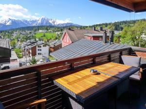 una mesa de madera en un balcón con vistas a las montañas en Apartment Bergidyll by Interhome en Flims