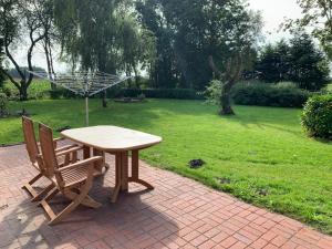 a picnic table and two chairs on a brick patio at Apartment Osterkamp by Interhome in Eversmeer