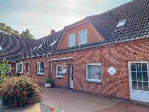 a red brick house with a brick driveway at Apartment Osterkamp by Interhome in Eversmeer