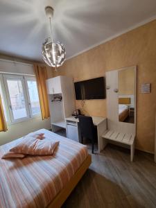 a hotel room with a bed and a desk and a mirror at Palafiori Rooms Sanremo in Sanremo