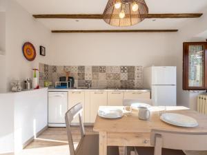 eine Küche mit einem Holztisch mit Stühlen und einem Esszimmer in der Unterkunft Apartment Giardino del Bosso-2 by Interhome in Germignaga