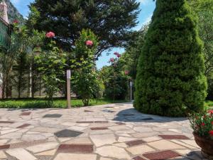 um jardim com um passadiço de pedra e árvores e flores em Holiday Home Oscha by Interhome em Lovran