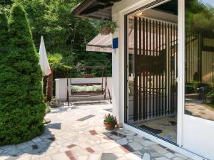 uma porta para um pátio com um banco num quintal em Holiday Home Oscha by Interhome em Lovran