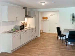 a kitchen with white cabinets and a table and chairs at Apartment Wangerooge by Interhome in Westerholt