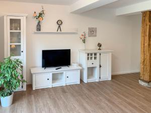 a living room with a tv and a white entertainment center at Apartment Wangerooge by Interhome in Westerholt