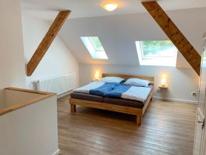 a bedroom with a bed with blue sheets and two windows at Apartment Wangerooge by Interhome in Westerholt