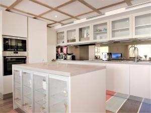una cucina con armadi bianchi e piano di lavoro di Apartment Chesa Piz Mezdi - St- Moritz by Interhome a Sankt Moritz