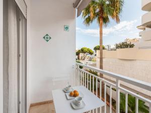 a balcony with a white table and a palm tree at Apartment Benasol in Benalmádena