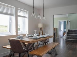 a dining room with a wooden table and chairs at Villa Ruadh by Interhome in Ose
