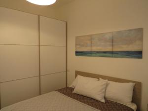 una camera da letto con un letto e un dipinto sul muro di APPARTAMENTO PETRARCA a Cervia