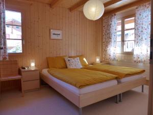 ein Schlafzimmer mit einem großen Bett und zwei Fenstern in der Unterkunft Apartment Haus Lohnerblick by Interhome in Kandersteg