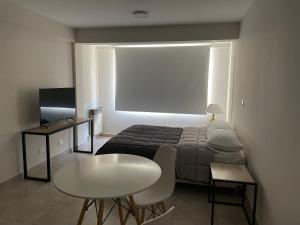 een kleine kamer met een bed en een tafel en een tafel en een tafelblad bij Departamento Céntrico Bariloche in Bariloche