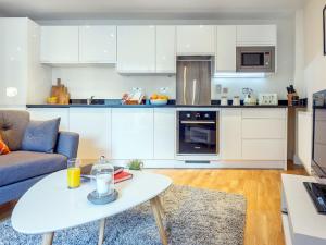 a living room with a table and a kitchen at Apartment Canary Gateway- Canary Wharf by Interhome in London