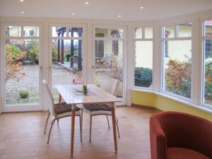 una sala da pranzo con tavolo, sedie e finestre di Holiday Home Altes Taubenhaus by Interhome a Zarrentin