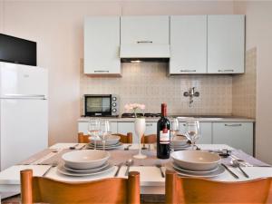 eine Küche mit einem Tisch und einer Flasche Wein in der Unterkunft Apartment Casa Armida-3 by Interhome in Rosolina Mare