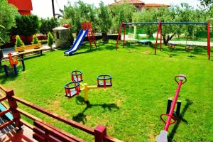 a park with a playground with a slide and swings at Sunday Resort in Gerakini