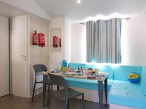 a dining room with a blue couch and a table at Holiday Home Happy Premium by Interhome in Torre Santa Sabina +15 photos