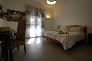 sypialnia z łóżkiem, krzesłem i oknem w obiekcie B&B Bivona w mieście Mazara del Vallo