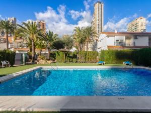 basen z palmami i budynek w obiekcie Apartment Rinconada Real-3 by Interhome w mieście Benidorm
