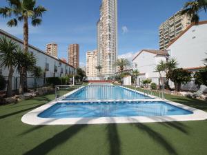 ein leerer Pool mit Palmen und Gebäuden in der Unterkunft Apartment Rinconada Real by Interhome in Benidorm