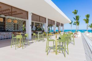 a patio area with chairs, tables and umbrellas at Tropical Deluxe Princess - All Inclusive in Punta Cana
