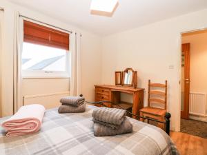 a bedroom with a bed and a window and a chair at 10 Annesley Park in Banchory